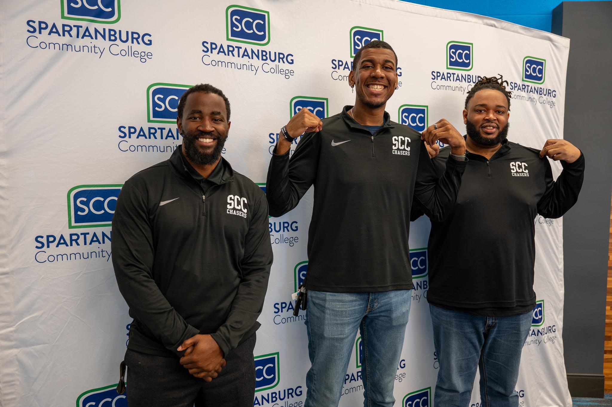 three men standing on front of Spartanburg backdrop