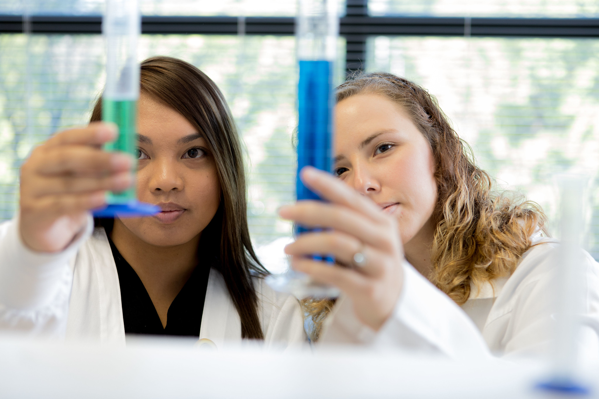 Image of two students looking at vile full of liquid