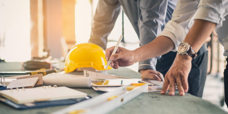 Close up of mans hands on building plans.