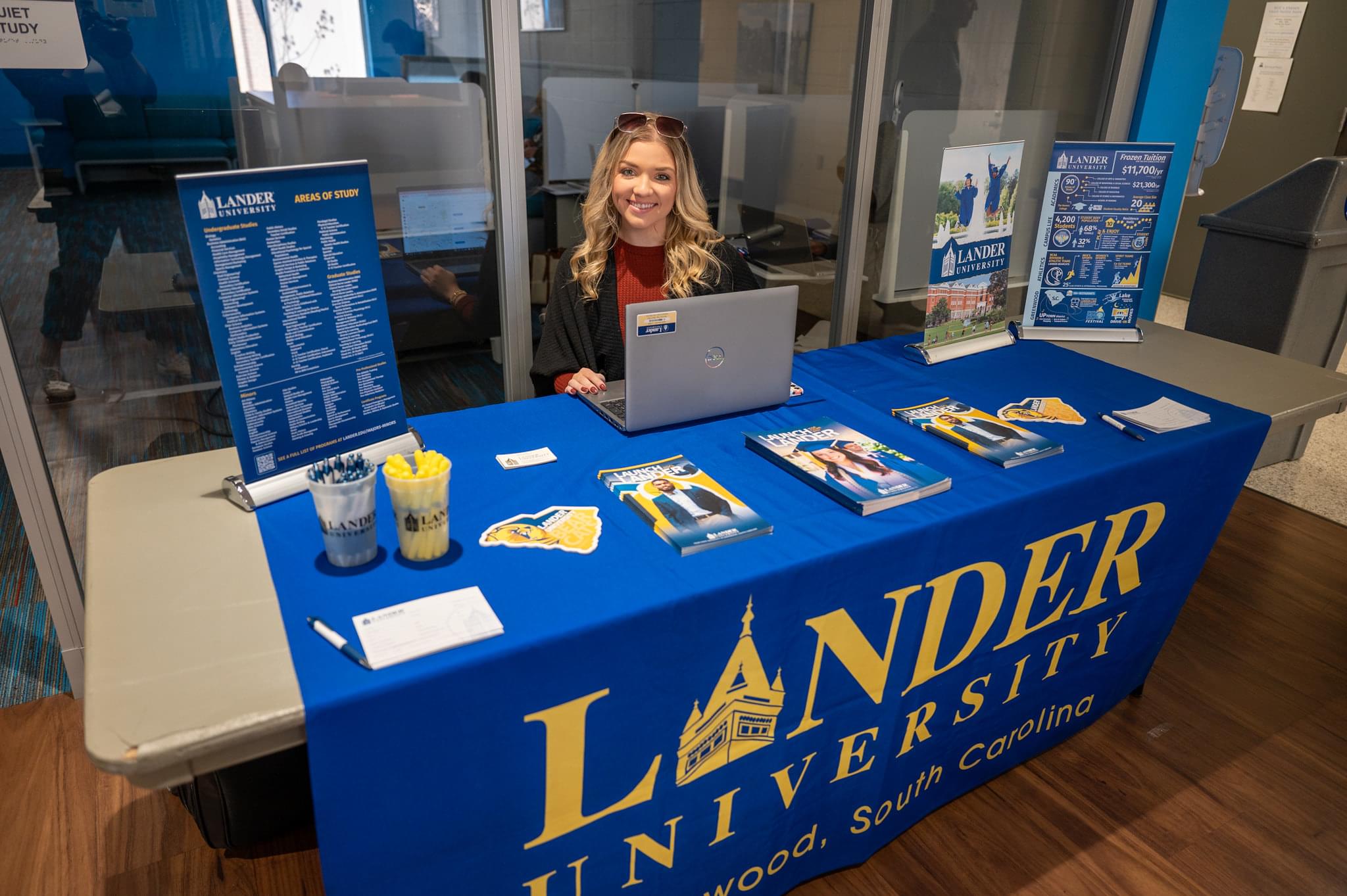 woman sitting at a table with Lander University branding